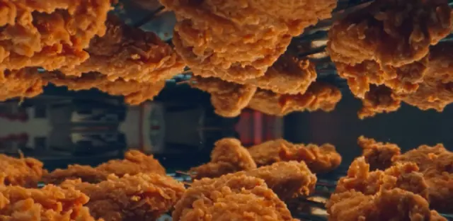 Kipstrips in een spiegelende tabletopcompositie uit de gepubliceerde KFC The Originals-campagne van Chuck Studios