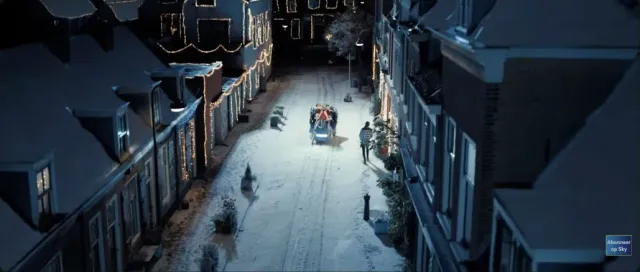Blauwe slee in een witte straat met historische gevels in de Sky Radio-kerstcommercial