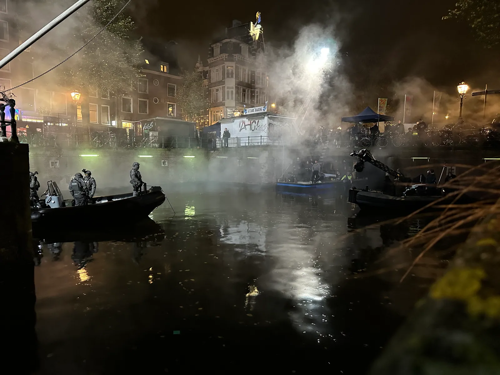 Werkboten en nevel boven het water tijdens een nachtopname van Amsterdamned II