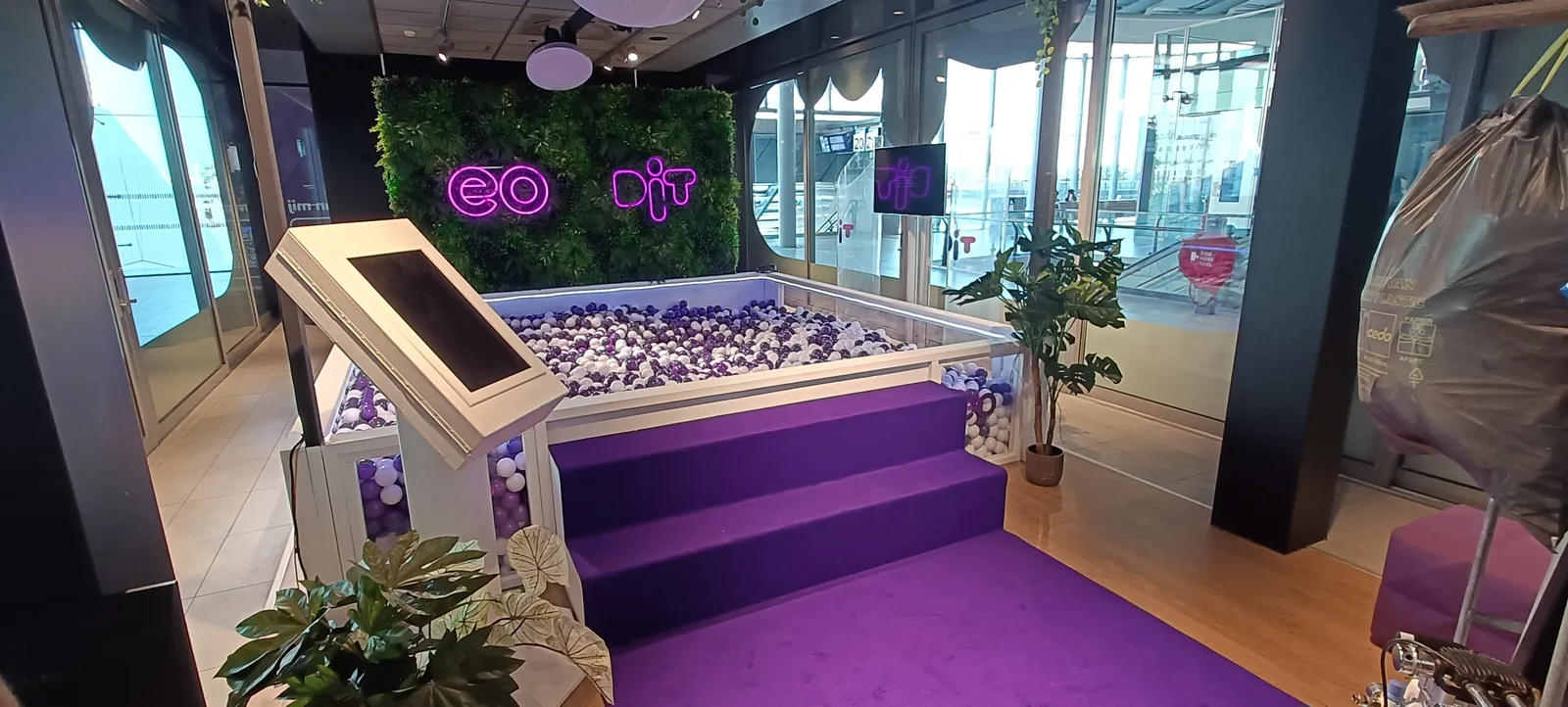 Paarse trap en ballenbak, fotopaal en EO- en DIT-logo’s in het pop-upinterieur op Utrecht Centraal