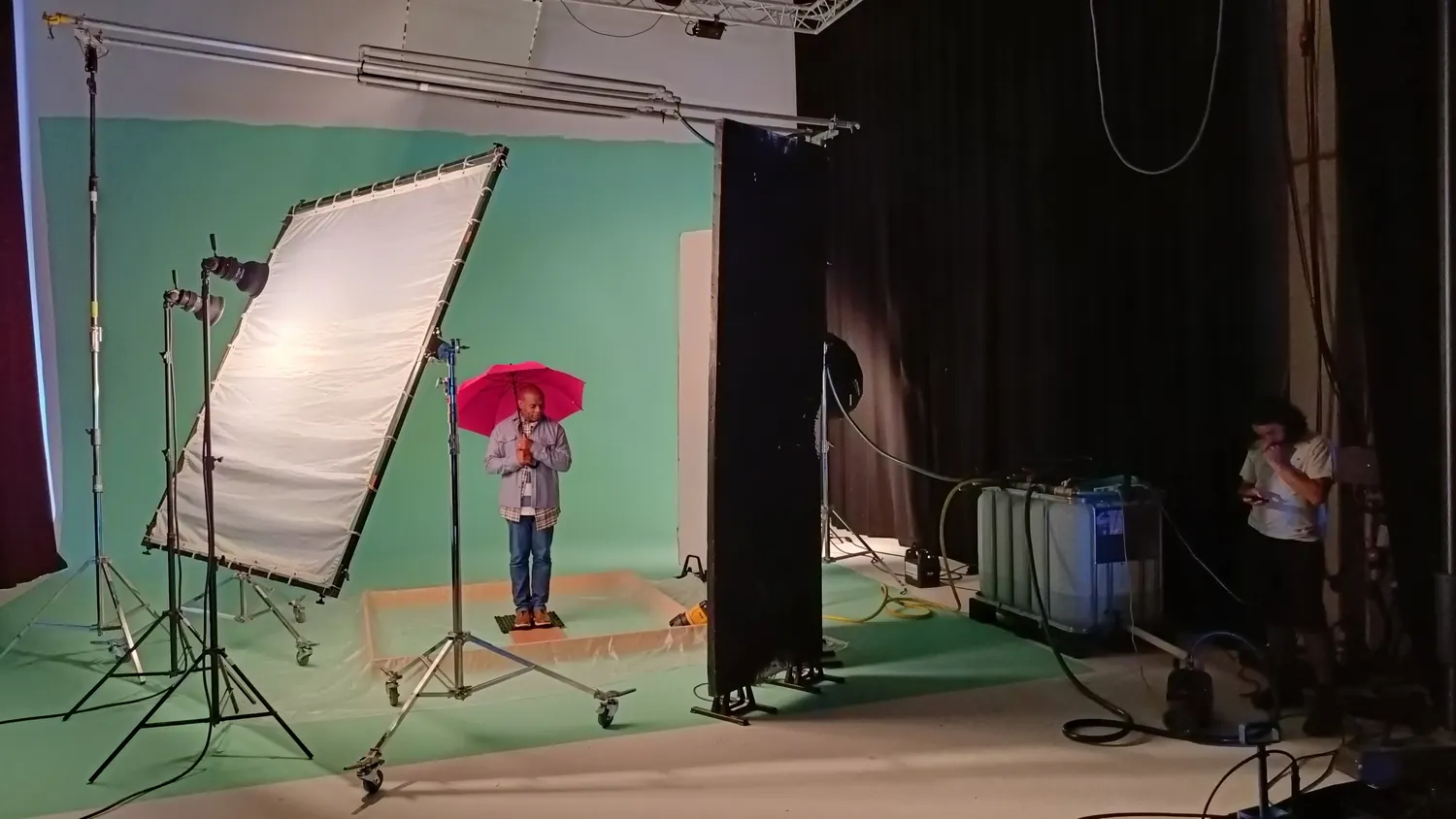 Studioset met roze paraplu, wateropvangbak en greenscreen voor de Etos-herfstcommercial